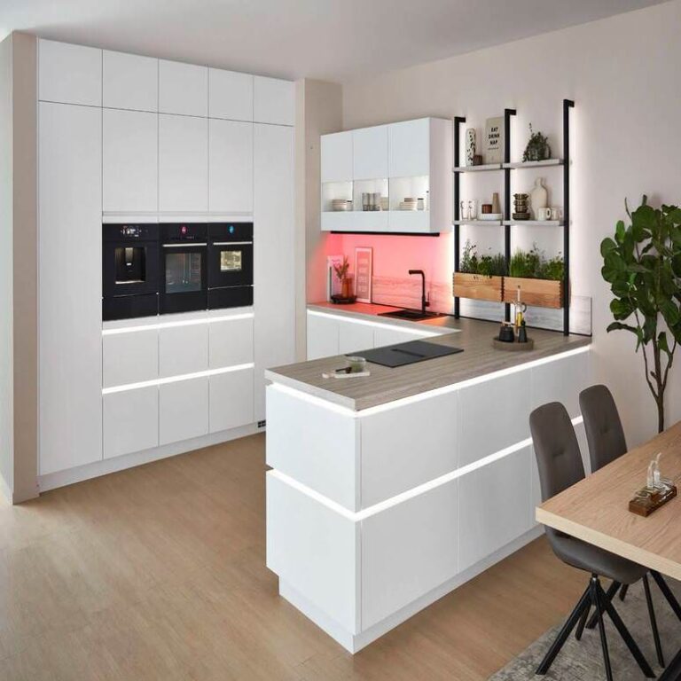 Moderne grifflose Küche in Weiß mit beleuchteter Kochinsel und Kräuterregal – Küchenstudio Heilbronn
