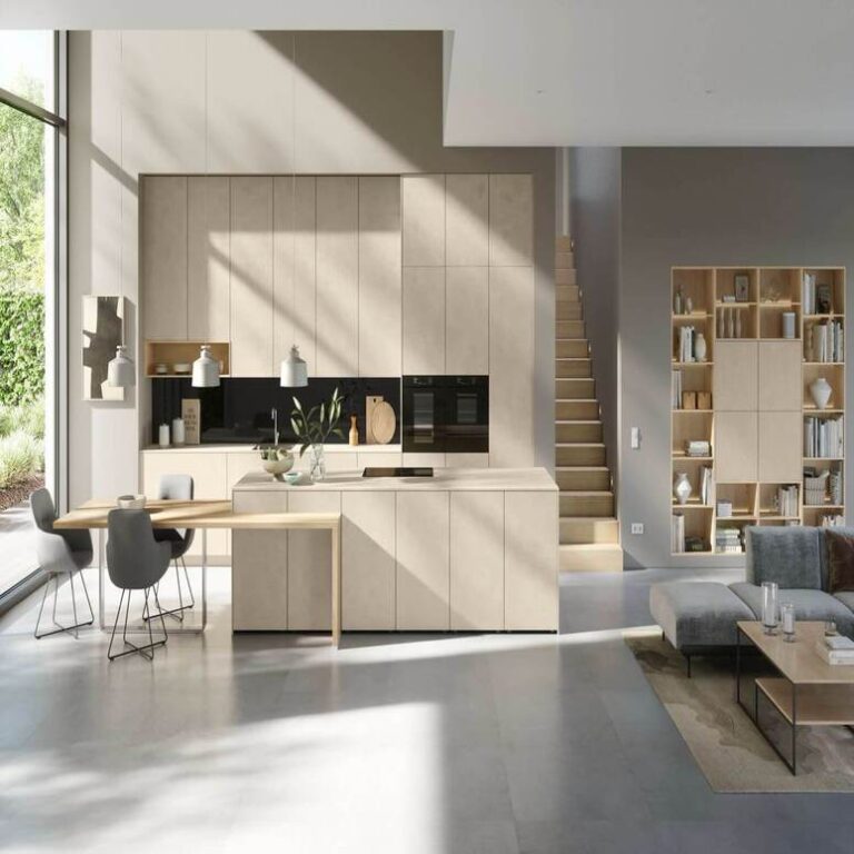 Offene moderne Küche in Beige mit Kochinsel, Essplatz und angrenzendem Wohnbereich – Küchenstudio Heilbronn